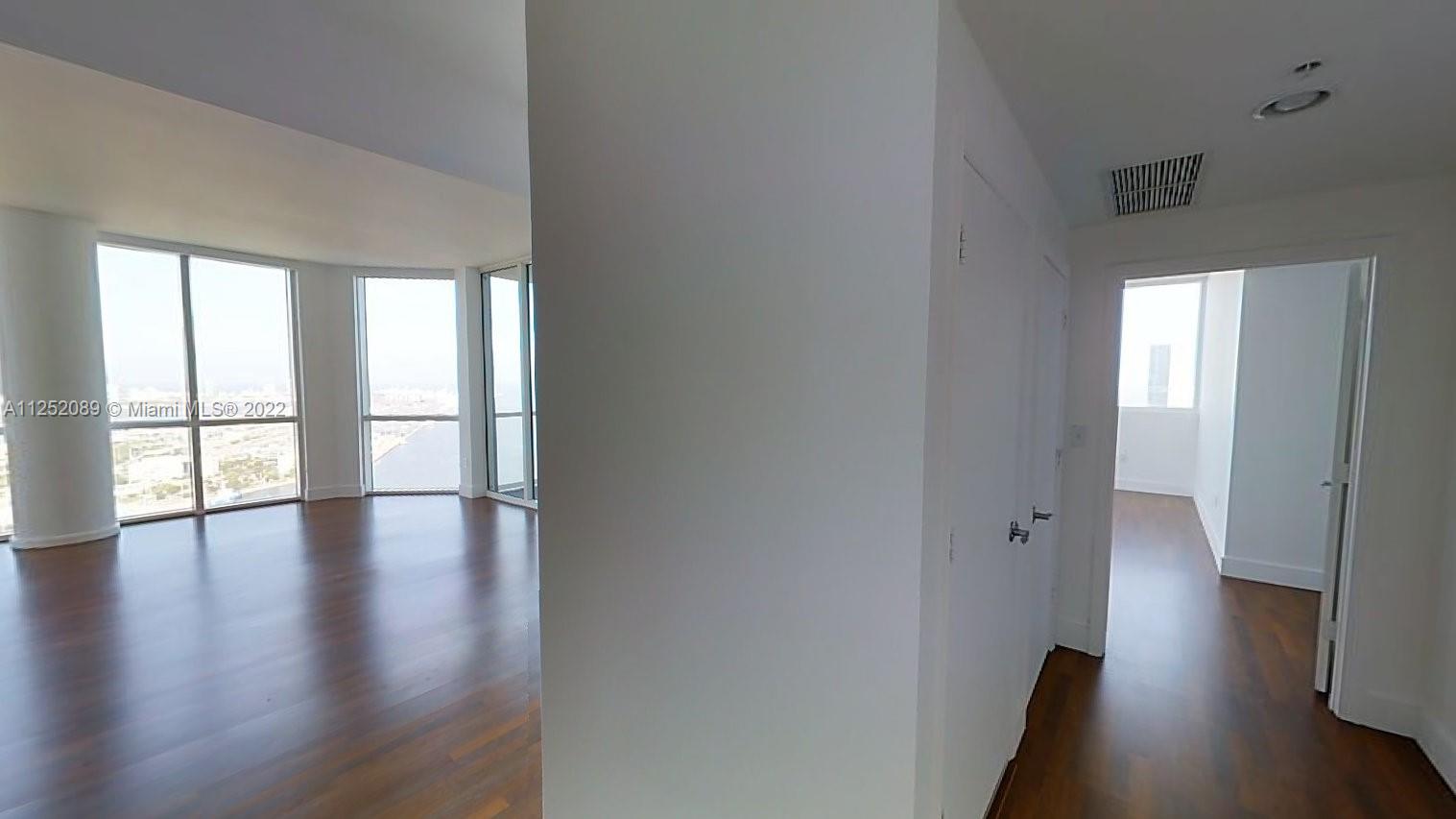 244 Biscayne Boulevard, Unit 4503 Miami, FL 33132 - Photo 8 of 33 wooden floor in an empty room with a window