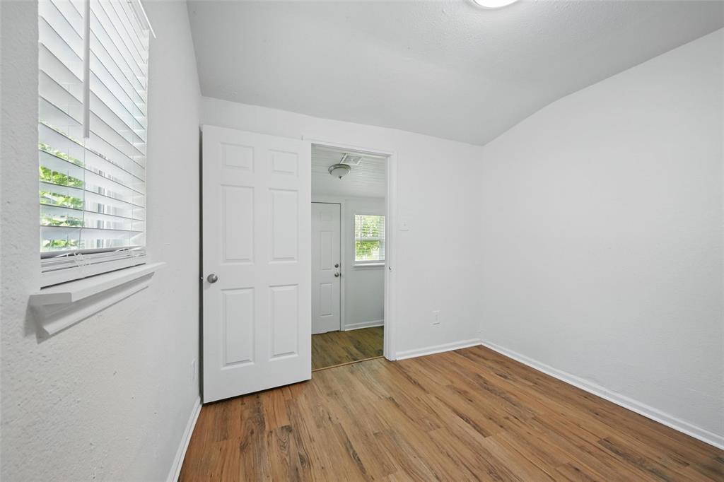 210 North 5th Avenue Denison, TX 75021 - Photo 12 of 20 an empty room with wooden floor and windows