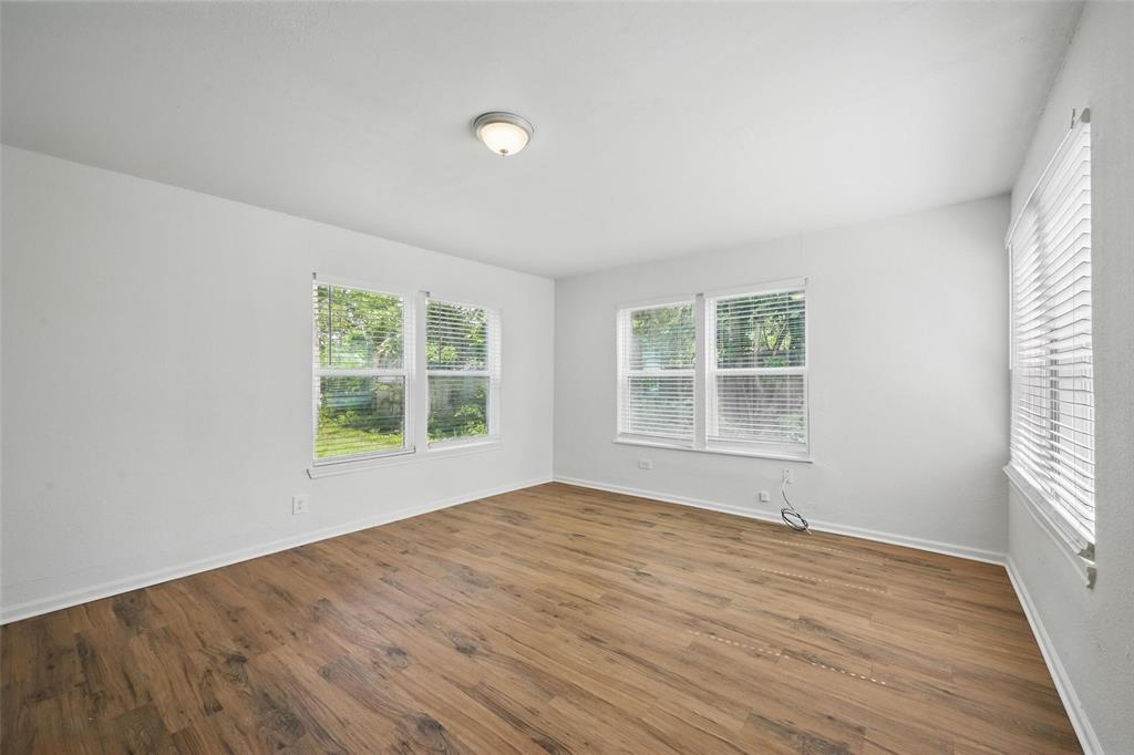 210 North 5th Avenue Denison, TX 75021 - Photo 13 of 20 a view of an empty room with wooden floor and a window