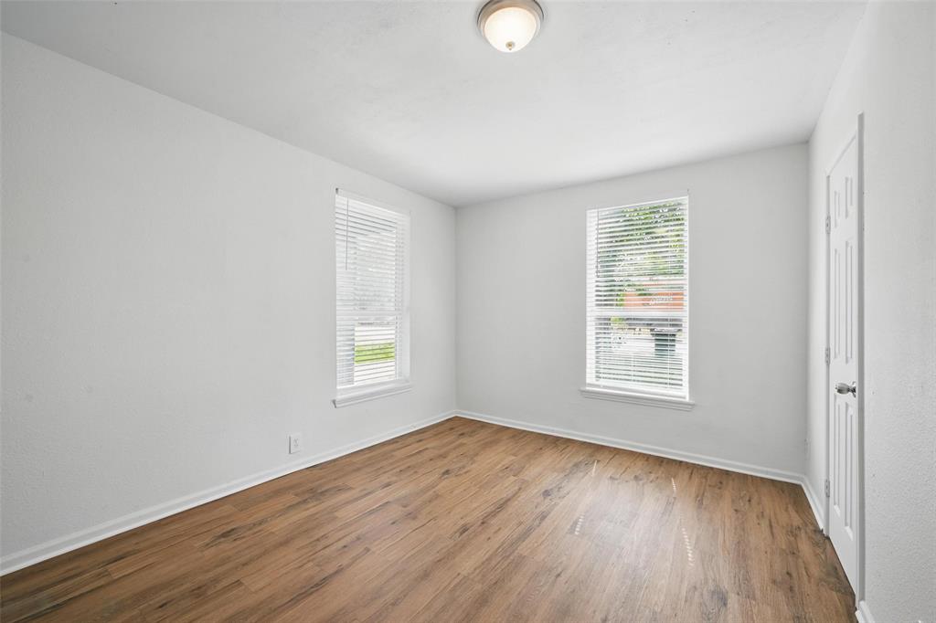 210 North 5th Avenue Denison, TX 75021 - Photo 16 of 20 an empty room with wooden floor and windows