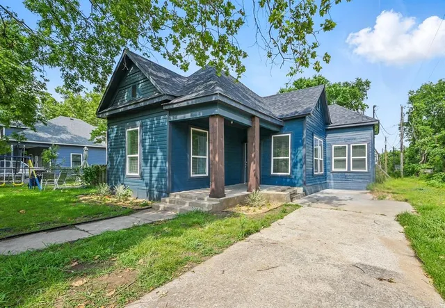 a front view of a house with a garden and yard