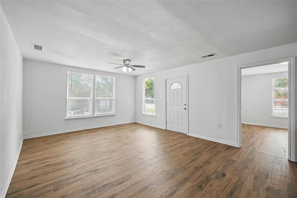 210 North 5th Avenue Denison, TX 75021 - Photo 3 of 20 an empty room with wooden floor cabinet and windows