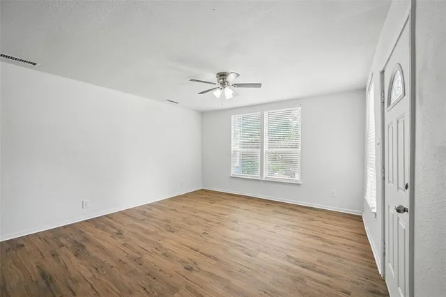 wooden floor in an empty room with a window