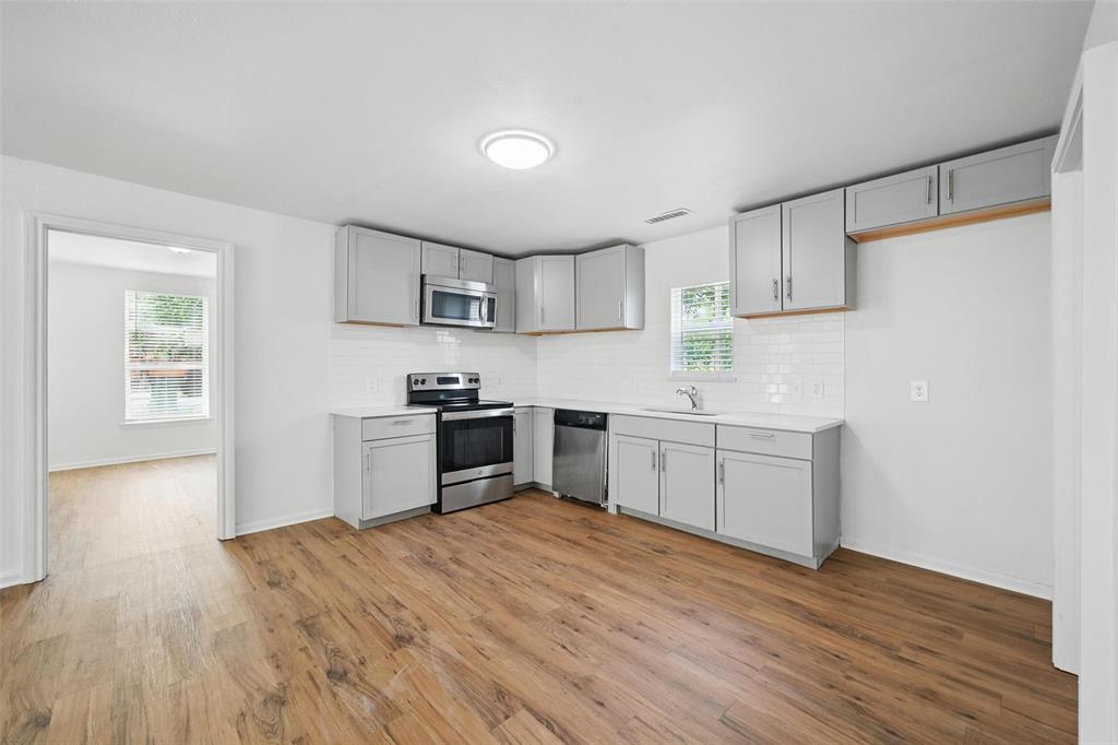 210 North 5th Avenue Denison, TX 75021 - Photo 7 of 20 a kitchen with granite countertop a sink cabinets and wooden floor