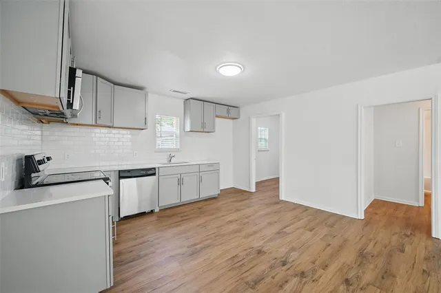 a kitchen with granite countertop a sink cabinets and wooden floor