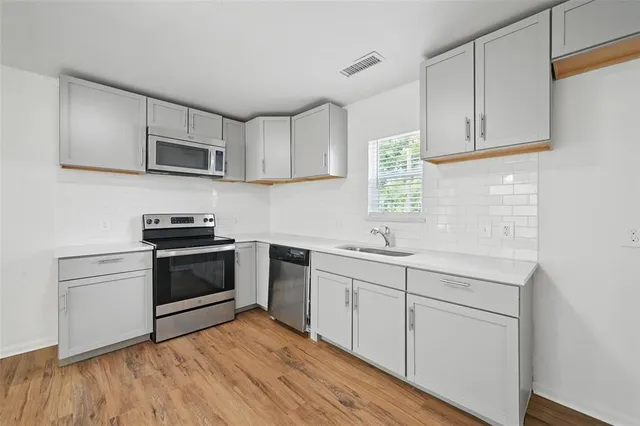 a kitchen with stainless steel appliances granite countertop a sink and a stove