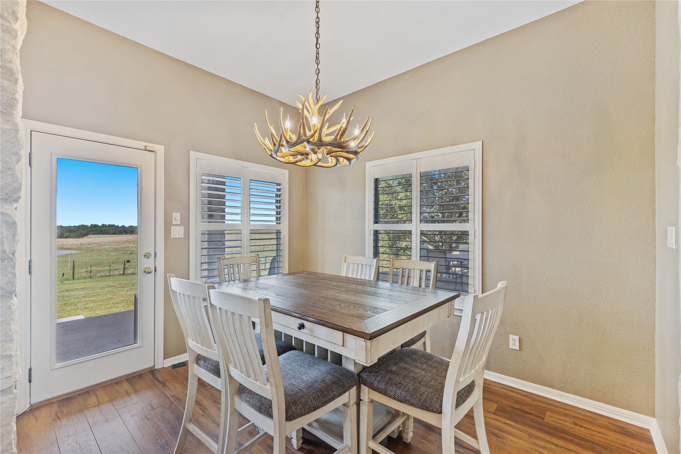 20145 Janak Road Coupland, TX 78615 - Photo 12 of 40 The breakfast area features rich hardwood floors and unique antler-style lighting with breathtaking views.