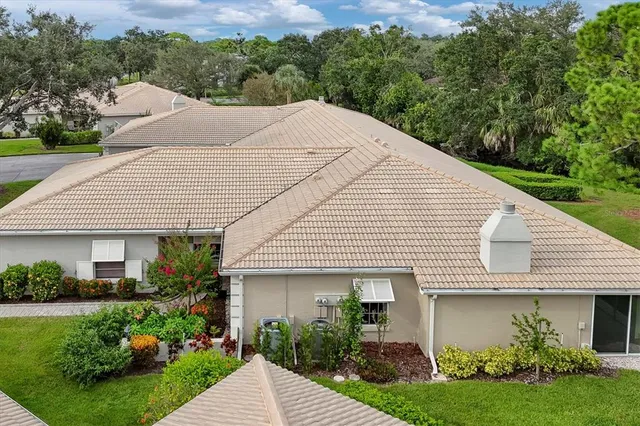 an aerial view of residential houses with outdoor space and trees