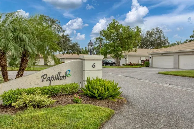 a view of a house with a yard and potted plants