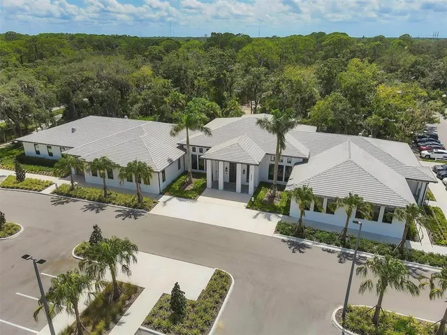 a hallway with a lots of white furniture a rug and a large window