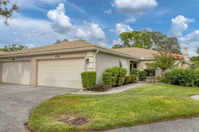 a front view of a house with a yard and potted plants