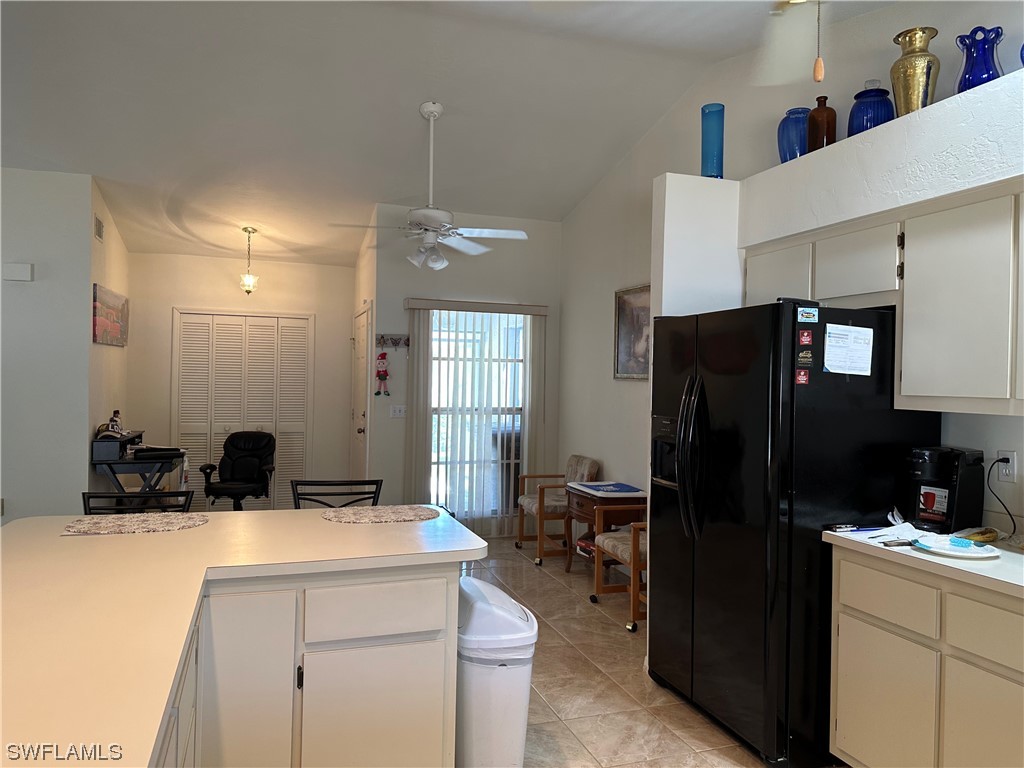 9805 Maplecrest Circle Lehigh Acres, FL 33936 - Photo 11 of 38 a kitchen with a refrigerator a sink and cabinets