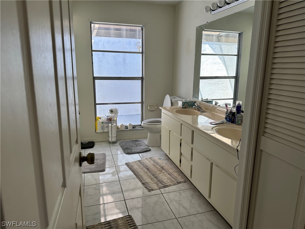 9805 Maplecrest Circle Lehigh Acres, FL 33936 - Photo 15 of 38 a bathroom with a sink toilet and a window