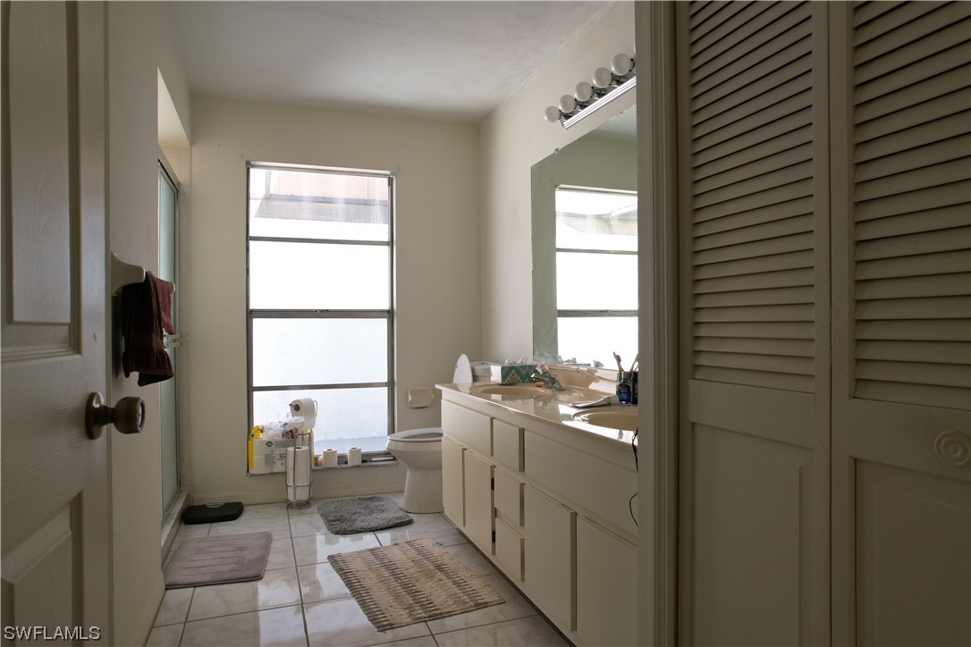 9805 Maplecrest Circle Lehigh Acres, FL 33936 - Photo 21 of 38 a bathroom with a toilet a sink and mirror