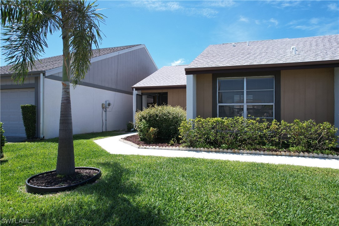 9805 Maplecrest Circle Lehigh Acres, FL 33936 - Photo 26 of 38 a view of house with a yard and potted plants