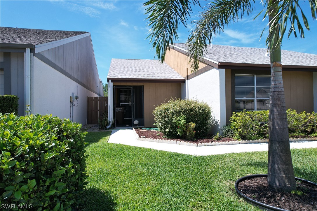 9805 Maplecrest Circle Lehigh Acres, FL 33936 - Photo 30 of 38 a front view of a house with a yard and garage
