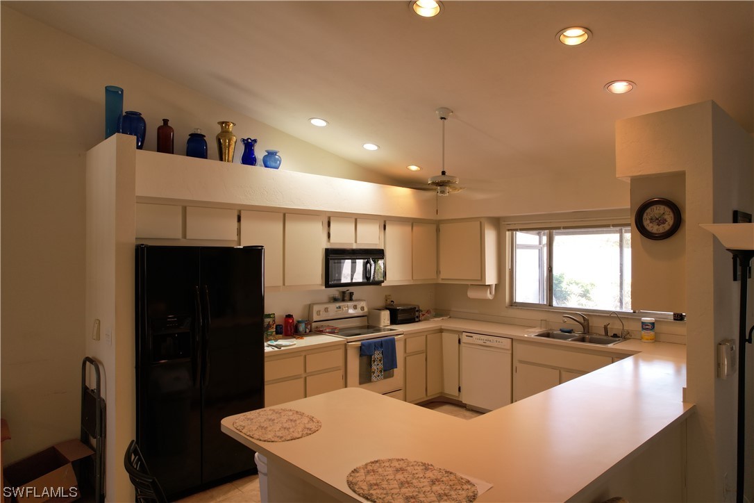 9805 Maplecrest Circle Lehigh Acres, FL 33936 - Photo 32 of 38 a kitchen with granite countertop a sink stove and refrigerator