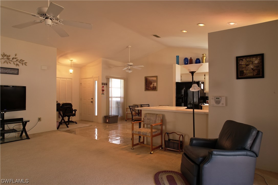 9805 Maplecrest Circle Lehigh Acres, FL 33936 - Photo 34 of 38 a living room with furniture and a flat screen tv