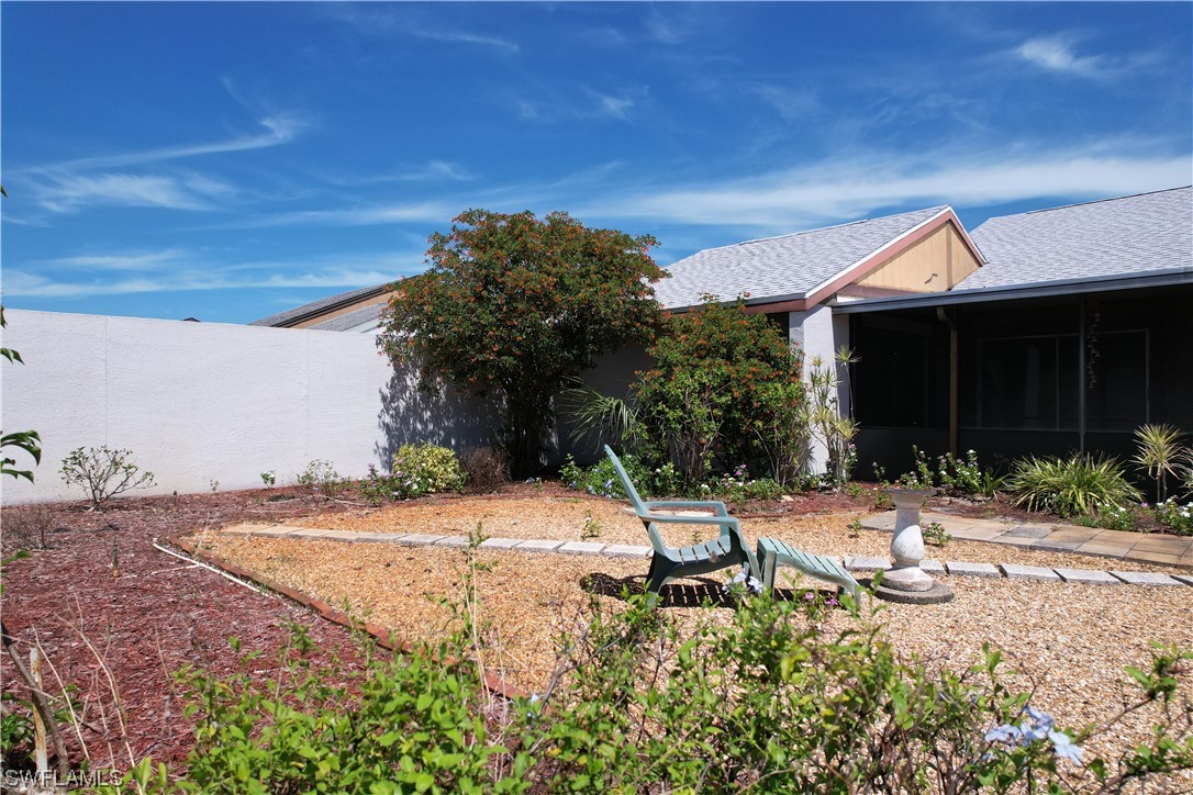 9805 Maplecrest Circle Lehigh Acres, FL 33936 - Photo 35 of 38 a backyard of a house with table and chairs