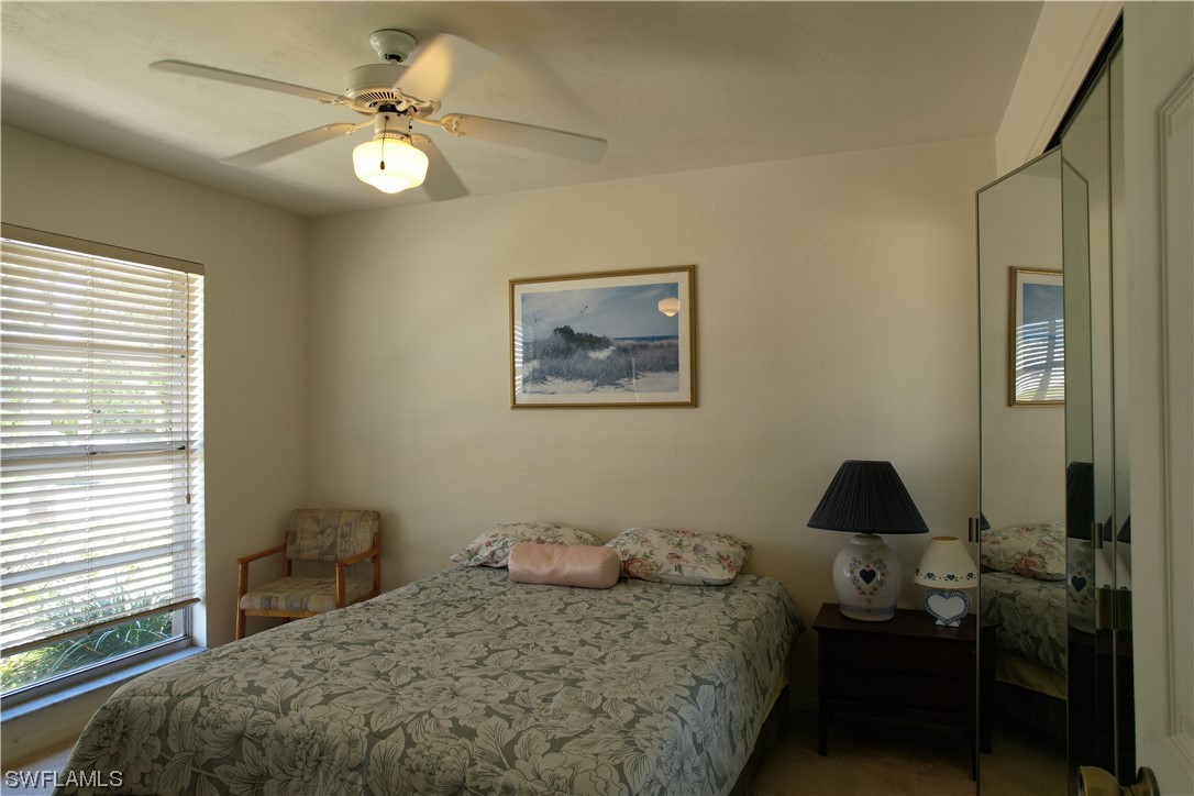 9805 Maplecrest Circle Lehigh Acres, FL 33936 - Photo 4 of 38 a bedroom with a bed and a chandelier