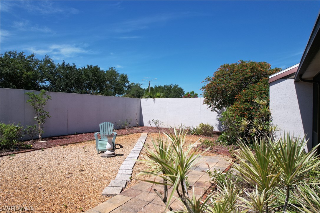 9805 Maplecrest Circle Lehigh Acres, FL 33936 - Photo 6 of 38 a backyard of a house with table and chairs
