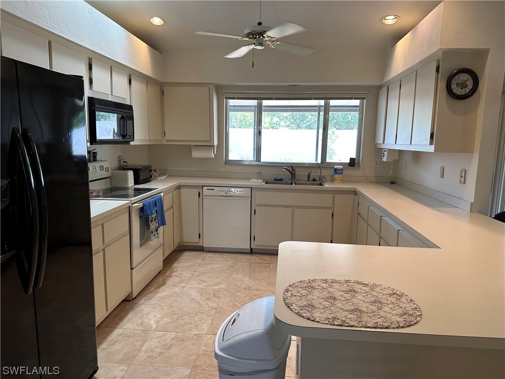 9805 Maplecrest Circle Lehigh Acres, FL 33936 - Photo 8 of 38 a kitchen with a sink stove and refrigerator