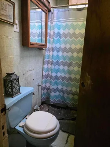 a bathroom with a toilet and a shower curtain