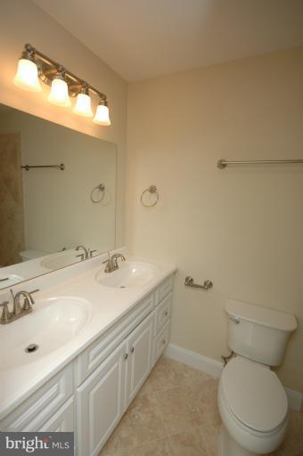 13207 Tamarack Road Silver Spring, MD 20904 - Photo 3 of 24 a bathroom with a granite countertop toilet sink and mirror