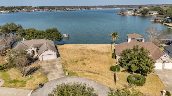 an aerial view of a house with swimming pool and large trees