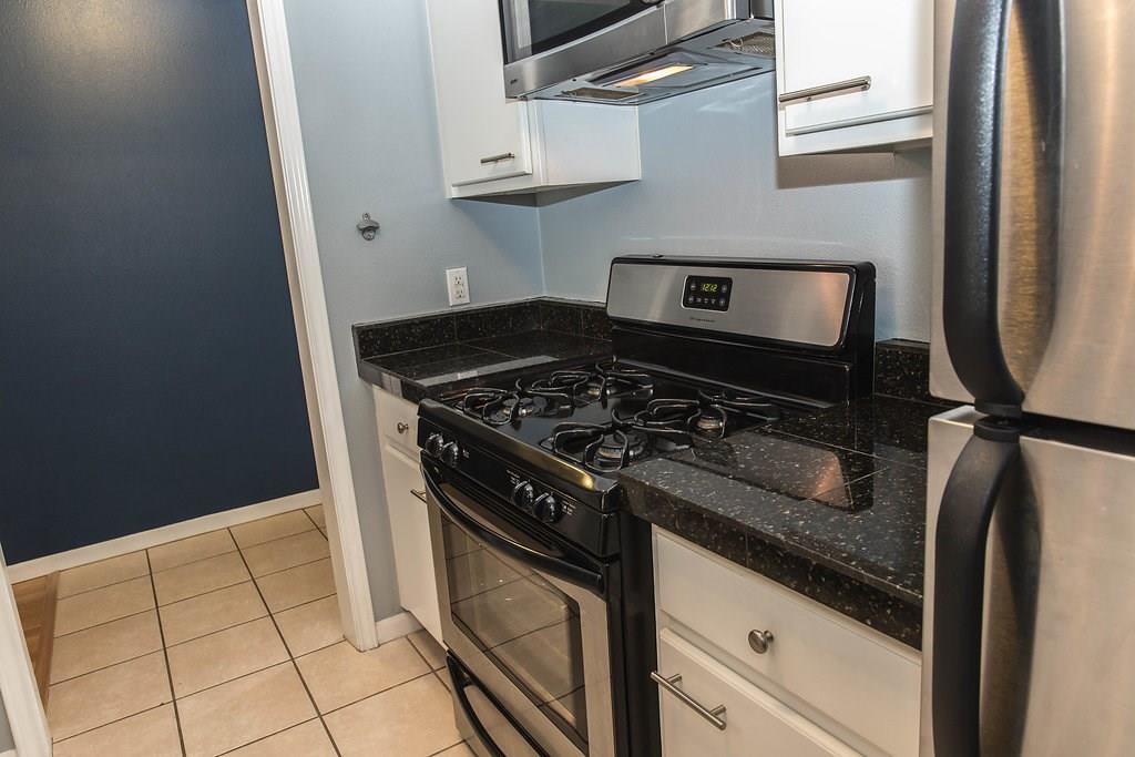 4209 Burnet Road, Unit 206 Austin, TX 78756 - Photo 7 of 20 Culinary dreams come alive with this functional kitchen, featuring durable granite countertops and sleek appliances.