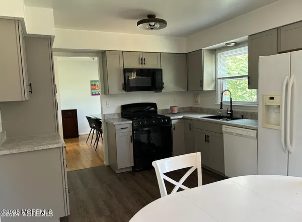 a kitchen with stainless steel appliances a refrigerator stove microwave and white cabinets