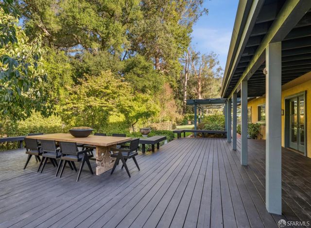 a bedroom with a bed a mirror and a large window with outer view