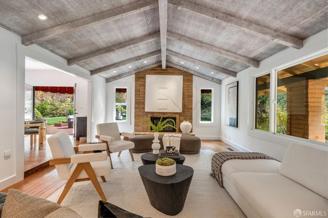 a living room with furniture a dining table and a chandelier