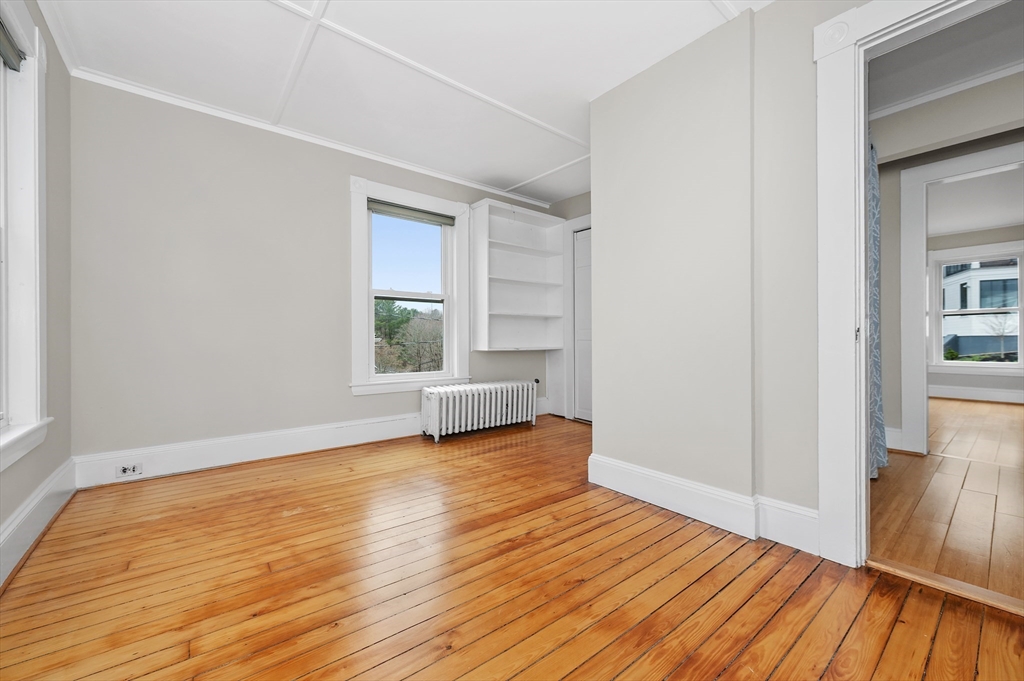 18 Bennett Street, Unit 2 Manchester, MA 01944 - Photo 16 of 21 a view of an empty room with wooden floor and a window