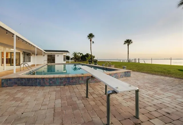 a view of a lake with a big yard and palm trees