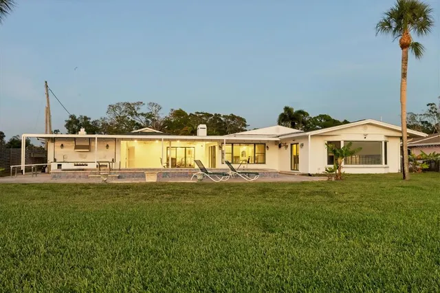 a view of a house with pool and chairs