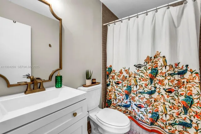 a bathroom with a sink a toilet and shower curtain