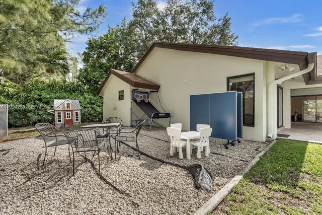 a view of a patio with table and chairs and potted plants
