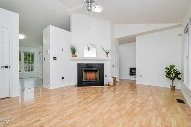 a view of an empty room with a fireplace and a window