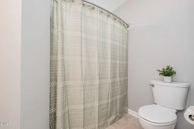 a white toilet sitting next to a shower curtain