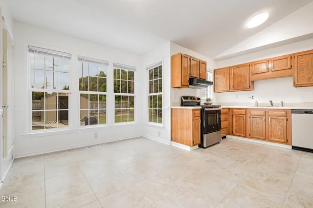a kitchen with stainless steel appliances granite countertop a stove top oven and cabinets