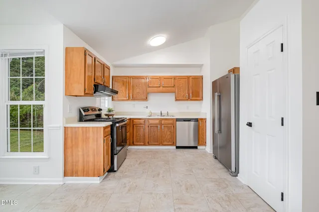 a kitchen with stainless steel appliances granite countertop a refrigerator and a sink