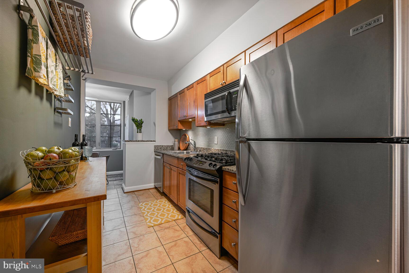 6722 3rd Street Northwest, Unit 203 Washington, DC 20012 - Photo 10 of 18 a kitchen with stainless steel appliances granite countertop a refrigerator a stove a sink and a microwave
