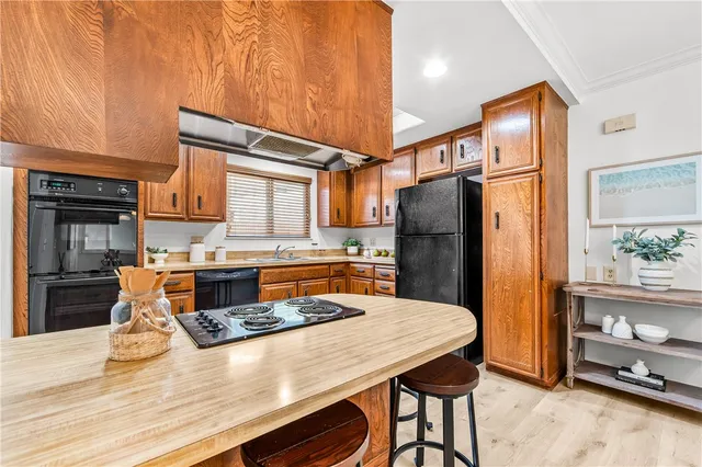 a kitchen with stainless steel appliances granite countertop a refrigerator a stove and a wooden cabinets