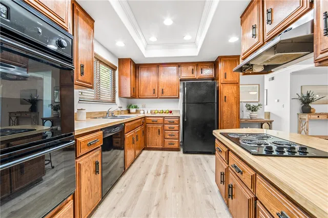 a kitchen with stainless steel appliances kitchen island granite countertop a stove refrigerator and cabinets