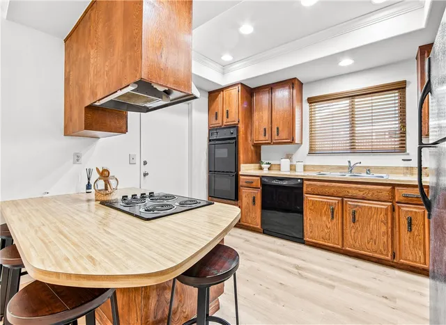 a kitchen with stainless steel appliances kitchen island granite countertop a sink a stove a kitchen island with a dining table and chairs