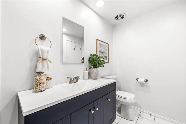 a bathroom with a sink vanity granite and toilet