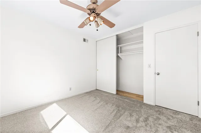 an empty room with a ceiling fan and a window