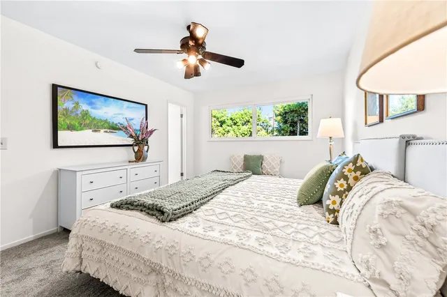 a spacious bedroom with a large bed and a chandelier
