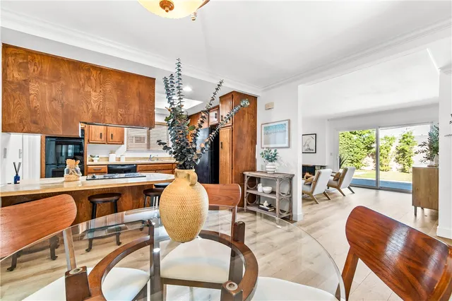 a kitchen with stainless steel appliances granite countertop a table chairs and a refrigerator